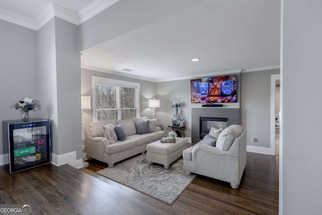 living room with a glass covered fireplace, crown molding, baseboards, and wood finished floors