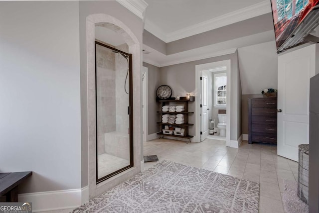 full bath with toilet, a shower stall, tile patterned flooring, crown molding, and baseboards