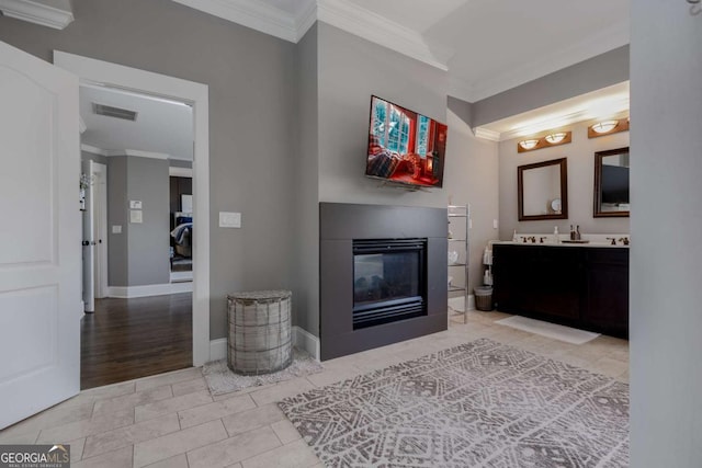 interior space featuring visible vents, crown molding, a multi sided fireplace, double vanity, and tile patterned floors