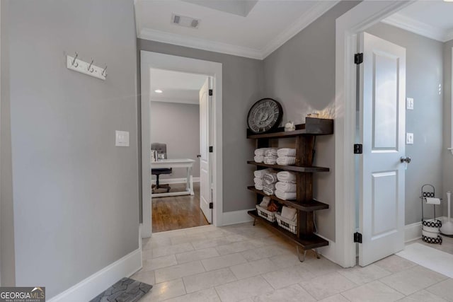 hall with light tile patterned floors, visible vents, baseboards, and ornamental molding