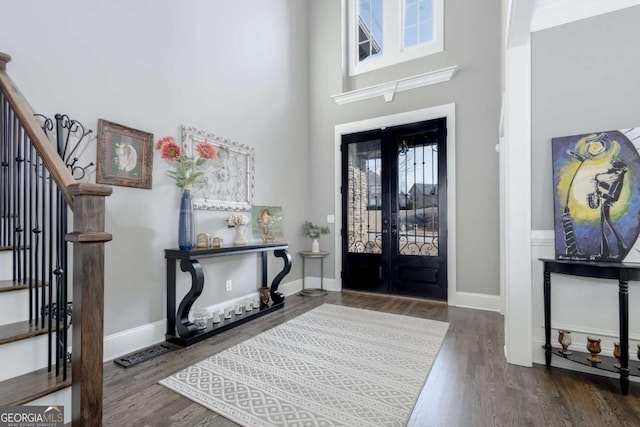 foyer with stairway, a healthy amount of sunlight, baseboards, and wood finished floors