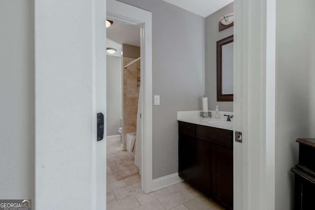 full bathroom with baseboards, vanity, and walk in shower