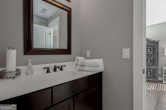 bathroom with visible vents, wood finished floors, and vanity