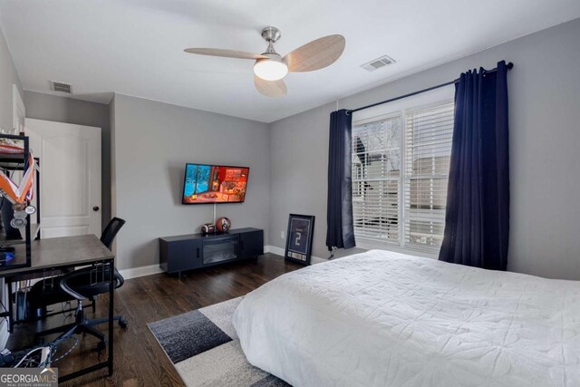 bedroom with ceiling fan, visible vents, baseboards, and wood finished floors