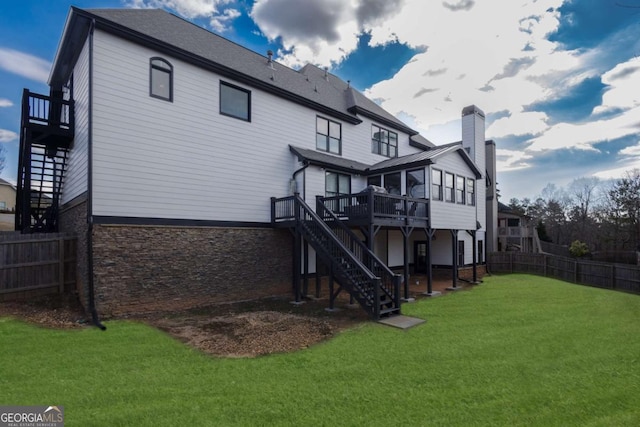 back of house featuring a yard, a wooden deck, stairs, and fence