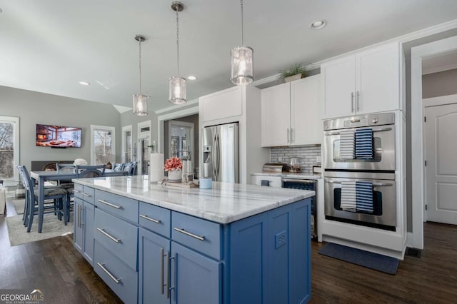 kitchen featuring blue cabinetry, white cabinetry, stainless steel appliances, and dark wood-style flooring