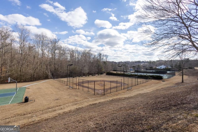 view of yard featuring community basketball court and fence