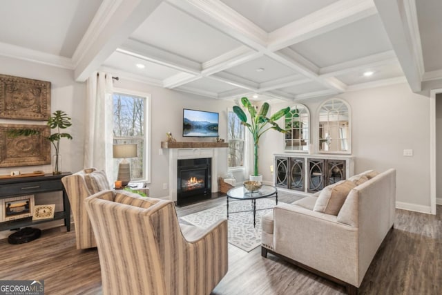 living area with wood finished floors, baseboards, coffered ceiling, beam ceiling, and a glass covered fireplace