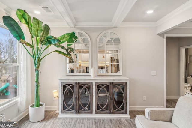 sitting room with visible vents, beam ceiling, ornamental molding, wood finished floors, and baseboards