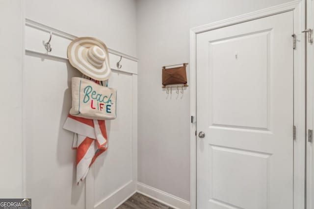 doorway with dark wood finished floors and baseboards