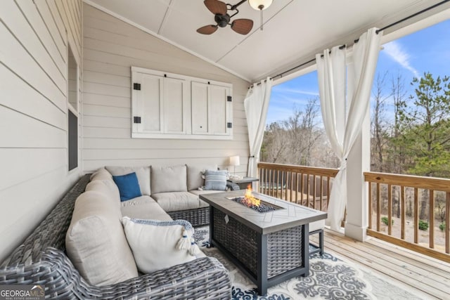 wooden deck with an outdoor living space with a fire pit and a ceiling fan