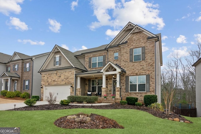 craftsman-style home featuring brick siding, a front yard, an attached garage, and driveway