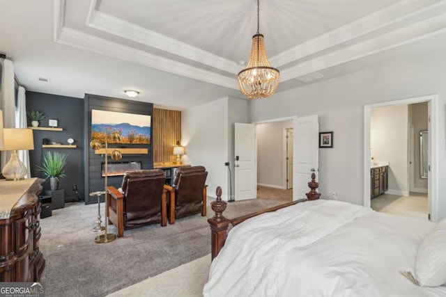 carpeted bedroom featuring a raised ceiling, a notable chandelier, crown molding, and ensuite bathroom