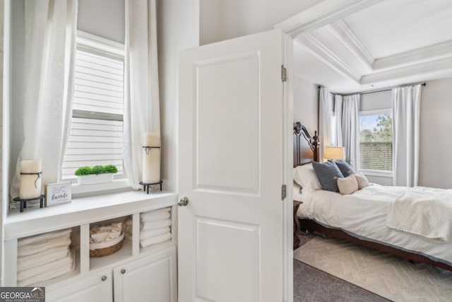 carpeted bedroom featuring a tray ceiling and ornamental molding