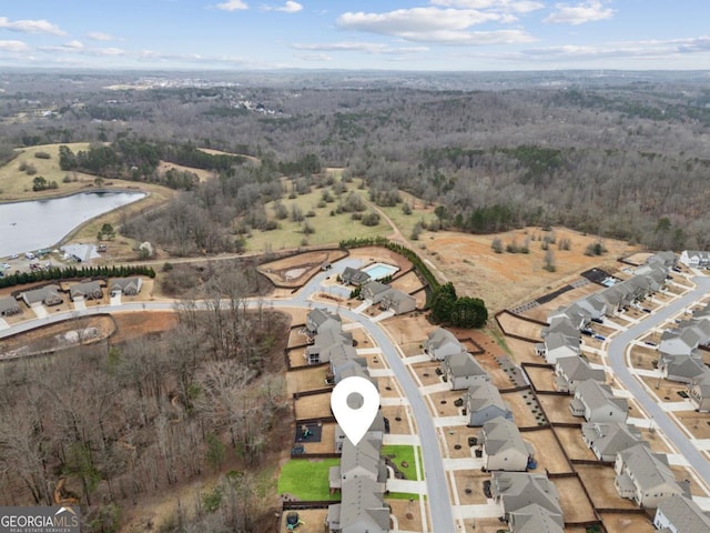 drone / aerial view featuring a view of trees and a water view