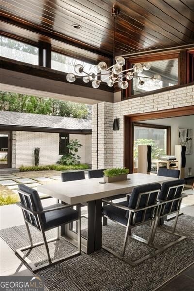 interior space featuring a chandelier, a healthy amount of sunlight, and wooden ceiling