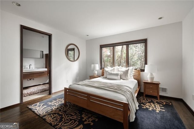 bedroom featuring wood finished floors, visible vents, and baseboards