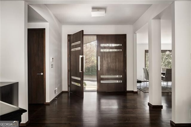 entryway featuring a healthy amount of sunlight, dark wood-style flooring, and baseboards