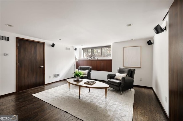 living area featuring visible vents, baseboards, and wood finished floors