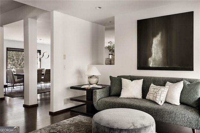 living area featuring visible vents, baseboards, and wood finished floors