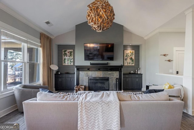 living room featuring visible vents, a tile fireplace, lofted ceiling, and wood finished floors