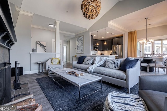 living area featuring dark wood-style floors, baseboards, a chandelier, and crown molding