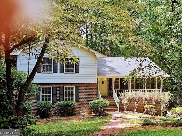 split level home featuring brick siding and a porch