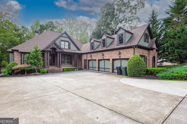 view of front of home with a garage, brick siding, concrete driveway, and a shingled roof