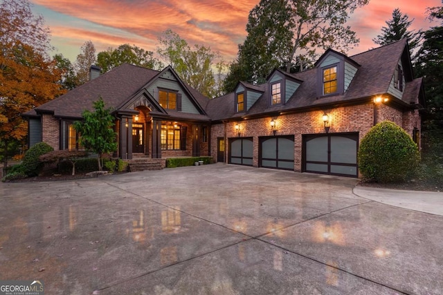 view of front facade featuring brick siding, concrete driveway, a garage, and roof with shingles