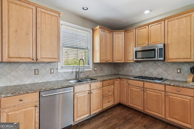 kitchen featuring a sink, dark wood-style floors, stone countertops, and stainless steel appliances