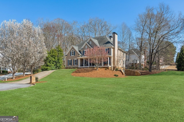 rear view of property with a chimney and a yard