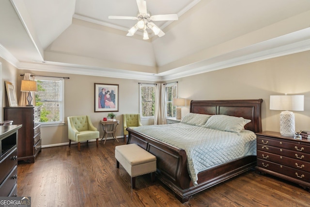 bedroom with baseboards, dark wood finished floors, ceiling fan, ornamental molding, and a raised ceiling