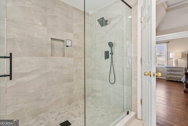 ensuite bathroom with crown molding, wood finished floors, a stall shower, and ensuite bathroom