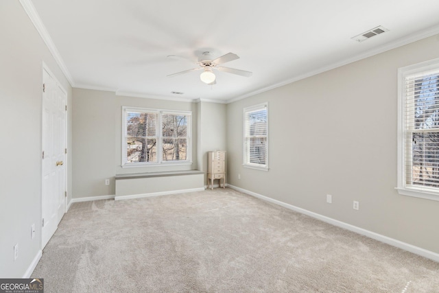 unfurnished room with baseboards, visible vents, carpet floors, ceiling fan, and crown molding