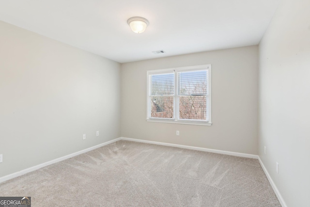 spare room with visible vents, baseboards, and carpet floors