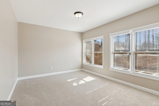 unfurnished room featuring carpet and baseboards