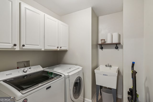 washroom with washer and clothes dryer, cabinet space, and baseboards