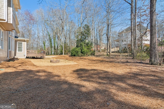 view of yard with an outdoor fire pit and a wooden deck