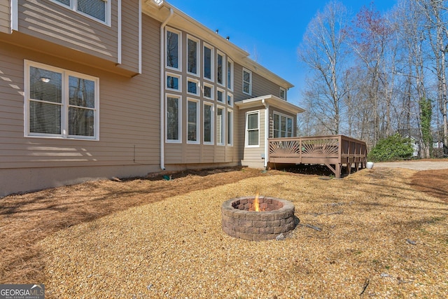 rear view of house featuring an outdoor fire pit and a deck