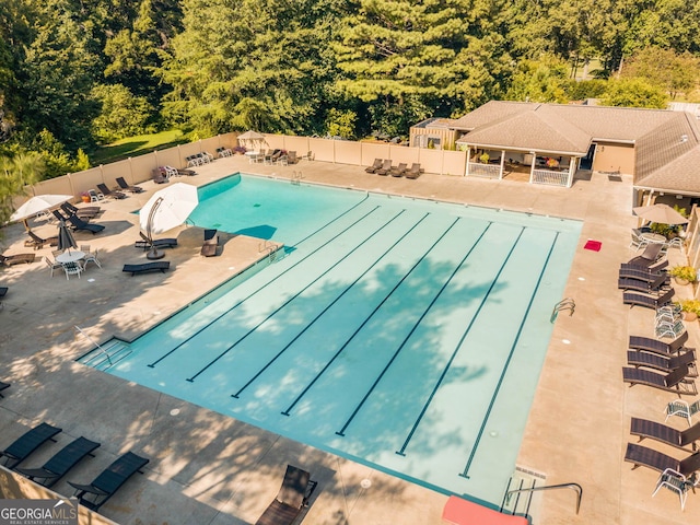 pool with a patio and fence