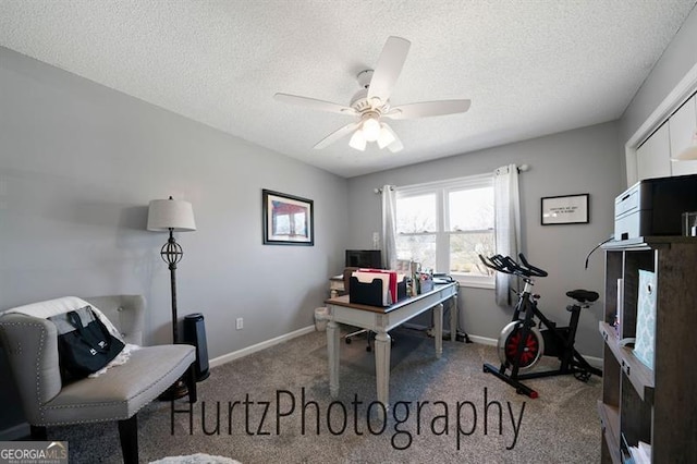 carpeted office space featuring a ceiling fan, baseboards, and a textured ceiling