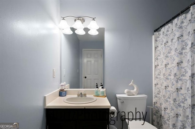 bathroom featuring a shower with shower curtain, toilet, and vanity