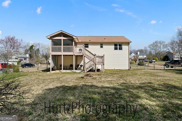 back of house with stairway, a yard, fence, and a sunroom