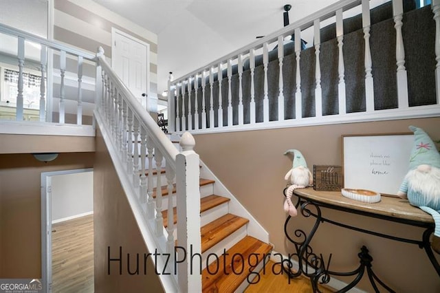 stairs featuring wood finished floors and baseboards