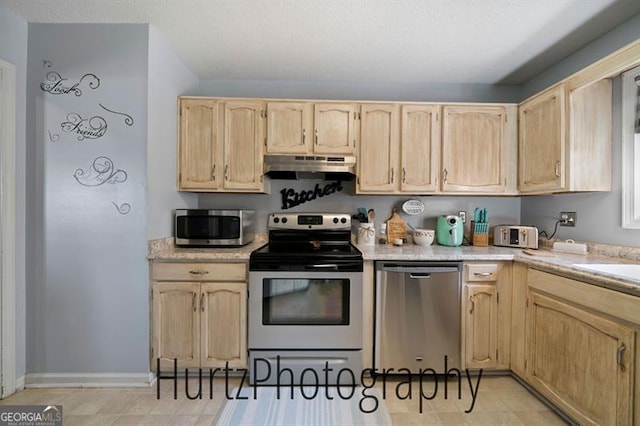 kitchen featuring under cabinet range hood, light brown cabinets, appliances with stainless steel finishes, and light countertops