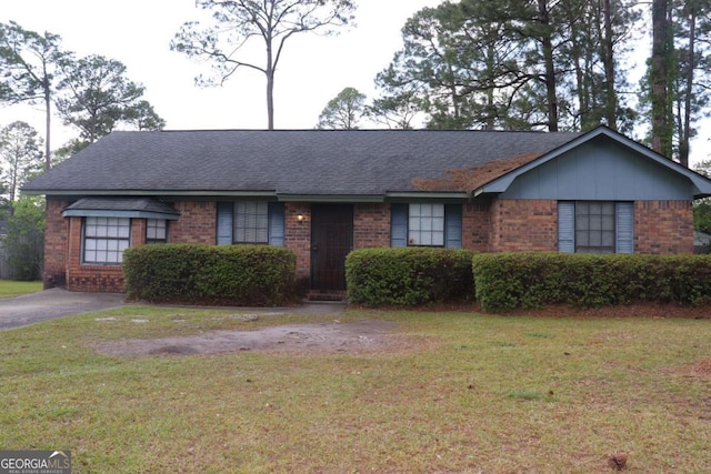 single story home with brick siding, roof with shingles, and a front yard