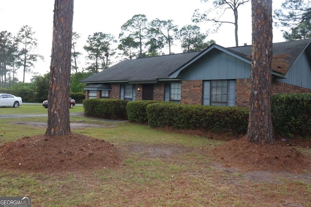 single story home with brick siding and a front yard