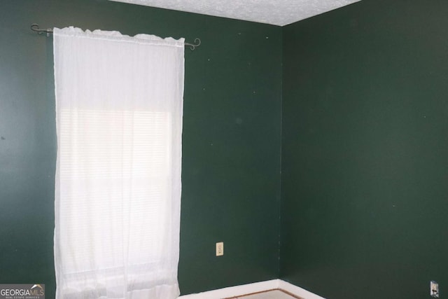 unfurnished room featuring a textured ceiling