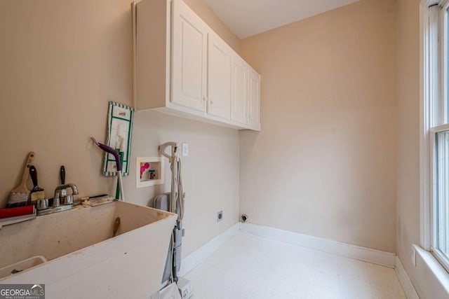 washroom with baseboards, hookup for a washing machine, tile patterned floors, cabinet space, and a sink