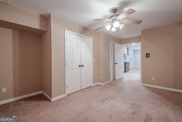 unfurnished bedroom featuring baseboards, carpet, and a ceiling fan
